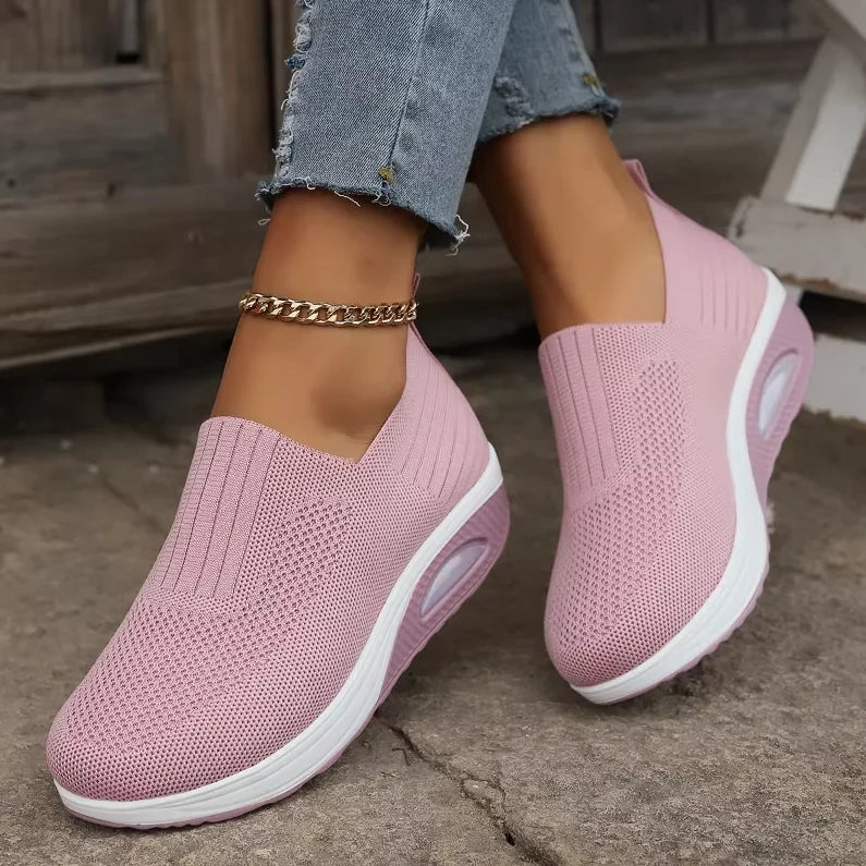a person wearing pink air cushion orthopedic shoes, showcasing the textured knit and white chunky sole