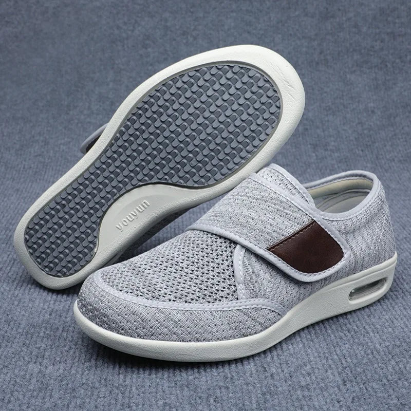 Light gray orthopedic shoes showing the breathable mesh upper and the patterned tread on the bottom sole.