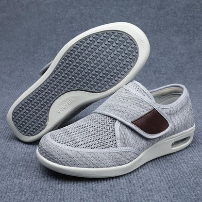 Light gray orthopedic shoes showing the breathable mesh upper and the patterned tread on the bottom sole.