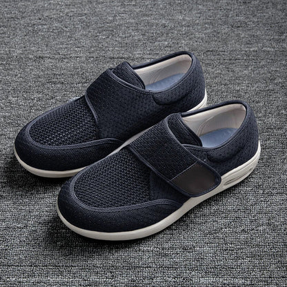 A pair of navy blue orthopedic shoes featuring a breathable mesh upper and velcro straps on a gray background.